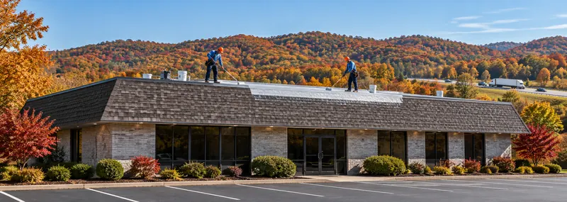 Roofers working on the shingle section of a commercial office building
